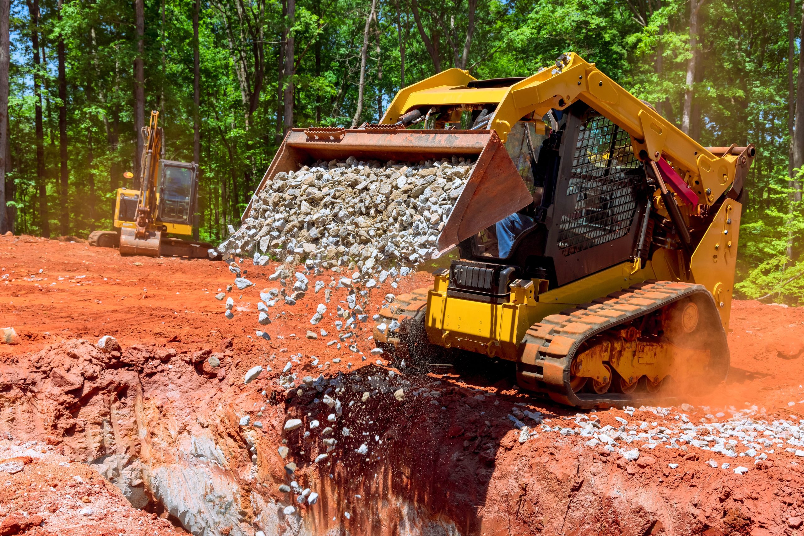 Unloading,Gravel,With,An,Excavator,Bucket,Skid,Steer,Loader,During